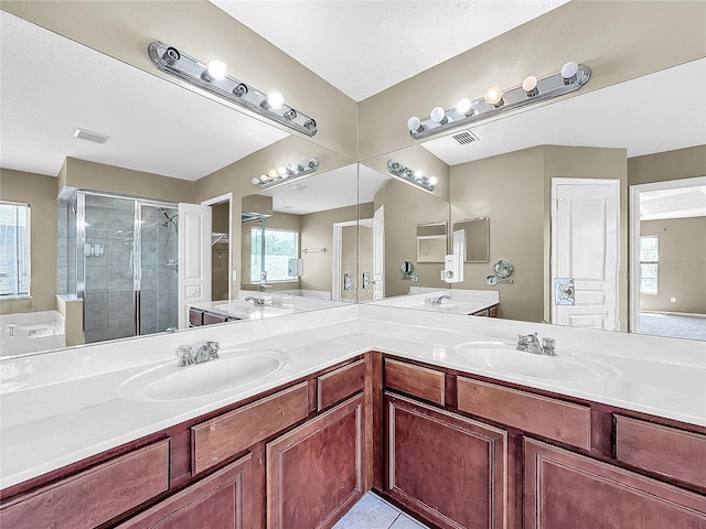 bathroom with tile patterned flooring, a shower with shower door, vanity, and a textured ceiling