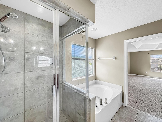 bathroom with a textured ceiling, plus walk in shower, and tile patterned flooring