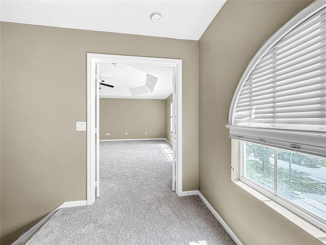 corridor featuring a textured ceiling and carpet flooring