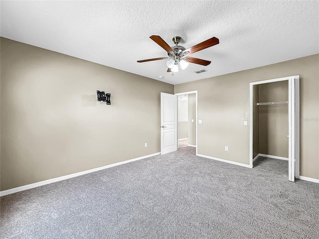 unfurnished bedroom with a closet, carpet, ceiling fan, and a textured ceiling