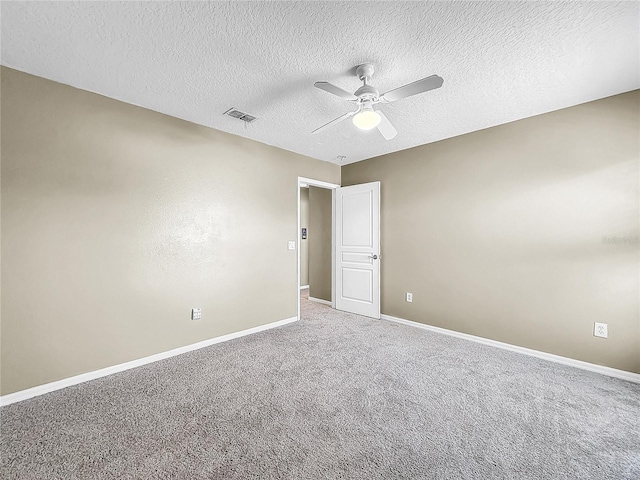 carpeted spare room with a textured ceiling and ceiling fan