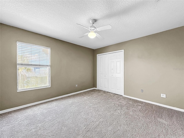 unfurnished bedroom featuring a closet, ceiling fan, carpet floors, and a textured ceiling