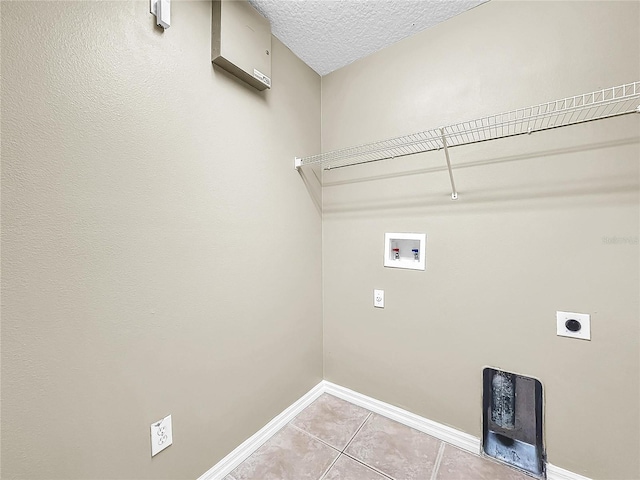 laundry area featuring washer hookup, hookup for an electric dryer, a textured ceiling, and light tile patterned floors