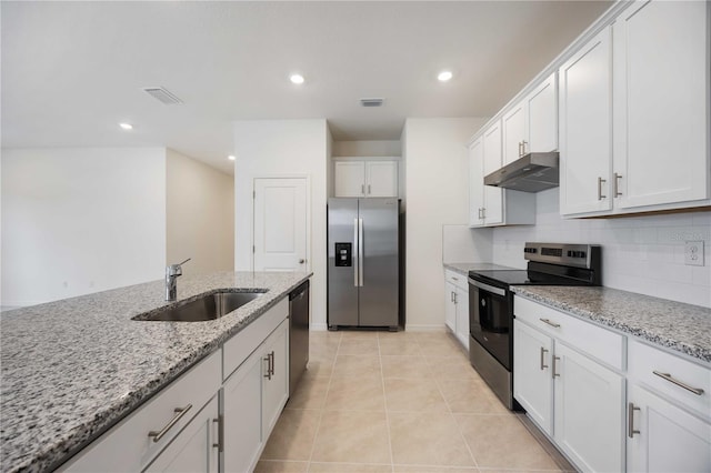 kitchen featuring light stone countertops, white cabinetry, stainless steel appliances, sink, and light tile patterned floors