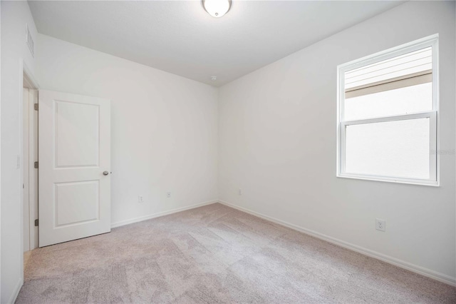 unfurnished room featuring light colored carpet