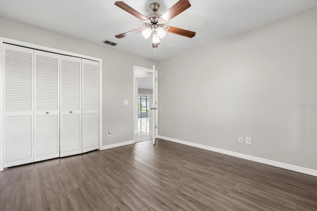 unfurnished bedroom featuring ceiling fan, a closet, and dark hardwood / wood-style floors