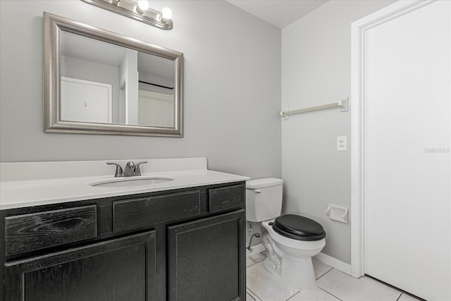 bathroom with vanity, tile patterned flooring, and toilet