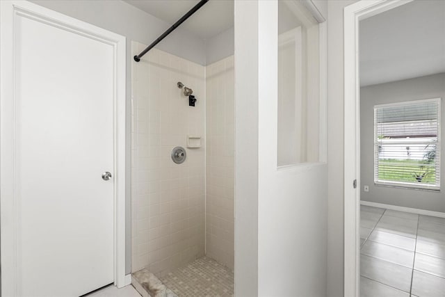 bathroom with a tile shower and tile patterned floors