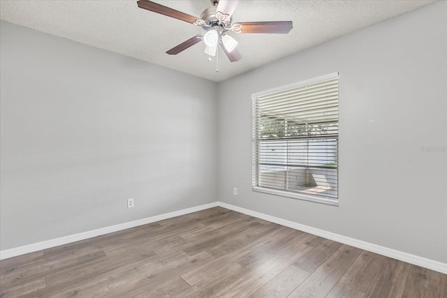 empty room featuring light wood-type flooring, a textured ceiling, and ceiling fan