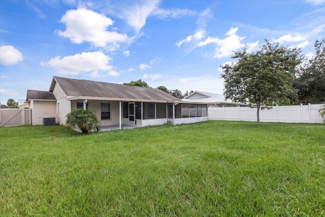 back of property featuring a yard, a sunroom, and central AC