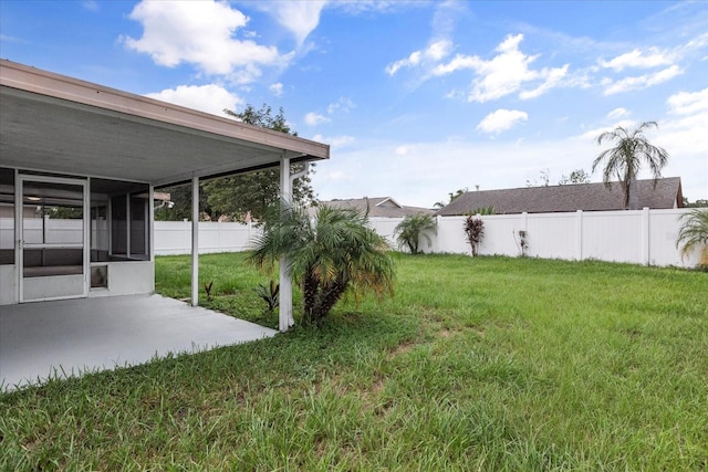 view of yard featuring a sunroom and a patio