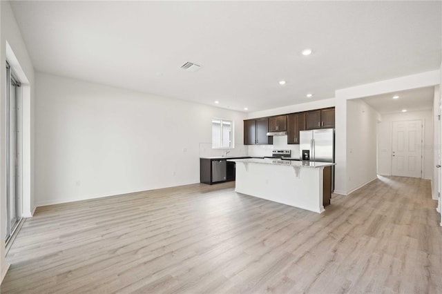 kitchen featuring a breakfast bar area, light hardwood / wood-style flooring, stainless steel appliances, and a center island