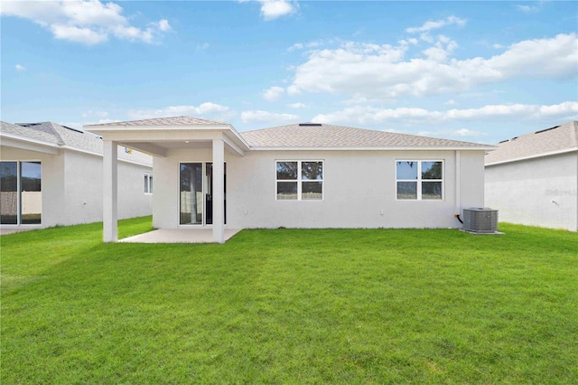 back of property with cooling unit, a patio area, and a lawn