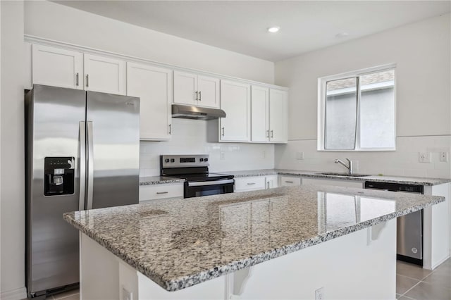 kitchen featuring white cabinets, appliances with stainless steel finishes, sink, and a kitchen island