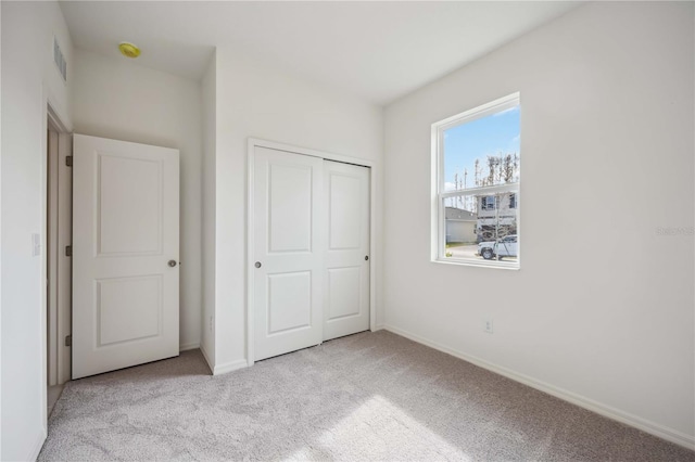 unfurnished bedroom featuring a closet and light carpet