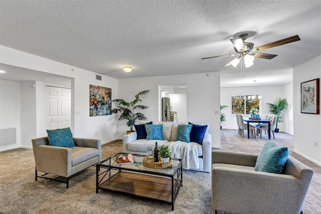 carpeted living room featuring a textured ceiling and ceiling fan