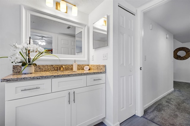 bathroom featuring visible vents, vanity, and baseboards