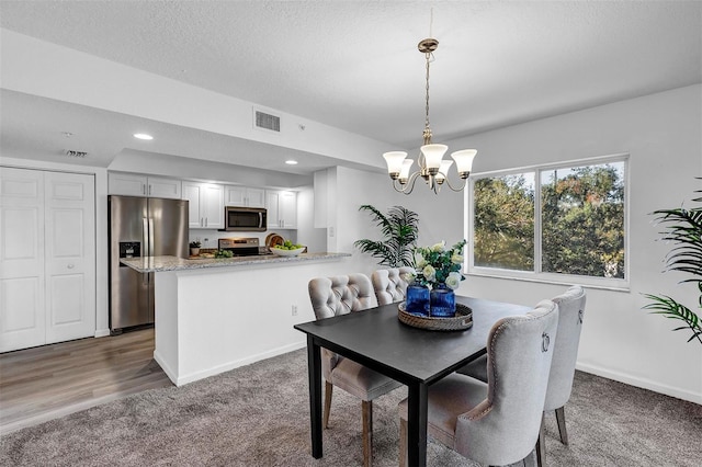 carpeted dining space with an inviting chandelier, visible vents, a textured ceiling, and recessed lighting