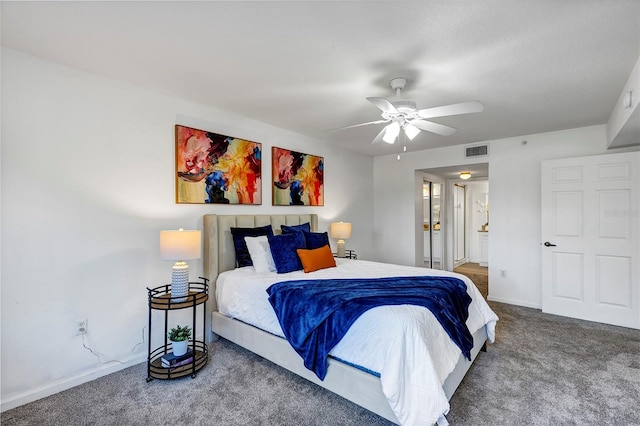 carpeted bedroom featuring ensuite bathroom, a ceiling fan, visible vents, and baseboards