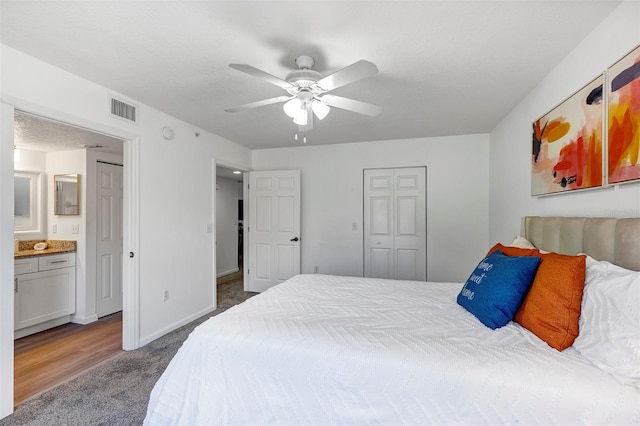 carpeted bedroom with a closet, visible vents, connected bathroom, ceiling fan, and baseboards