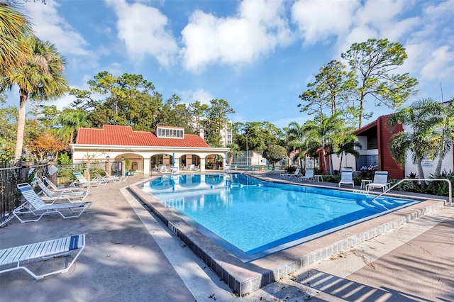 pool with a patio and fence