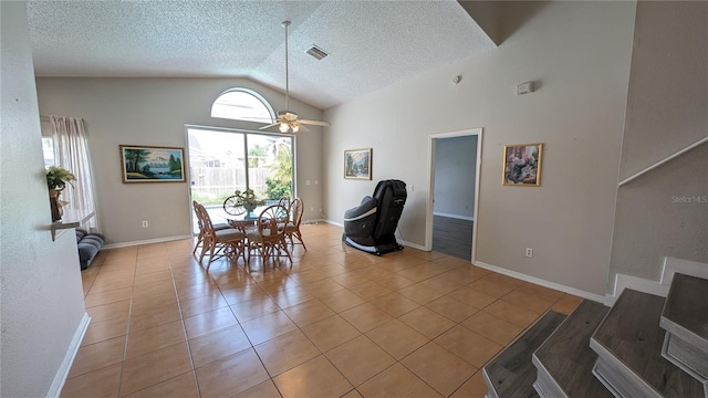 tiled dining area with ceiling fan, a textured ceiling, and vaulted ceiling