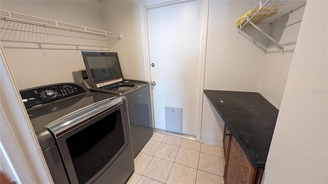 laundry area featuring washer and clothes dryer and light tile patterned flooring