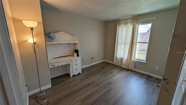 unfurnished bedroom featuring a textured ceiling and dark hardwood / wood-style flooring