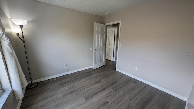 interior space with a textured ceiling and dark wood-type flooring