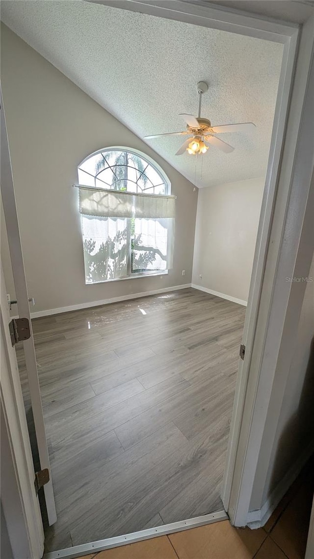 empty room featuring ceiling fan, a textured ceiling, and light wood-type flooring