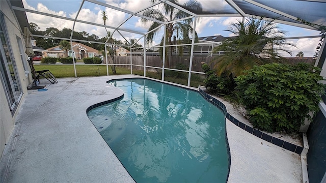 view of swimming pool with glass enclosure, a lawn, and a patio