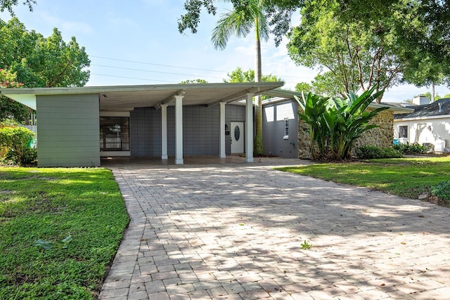 view of front facade with a carport and a front lawn