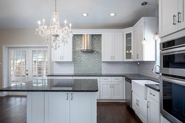 kitchen with dark hardwood / wood-style floors, wall chimney range hood, stainless steel appliances, and white cabinets