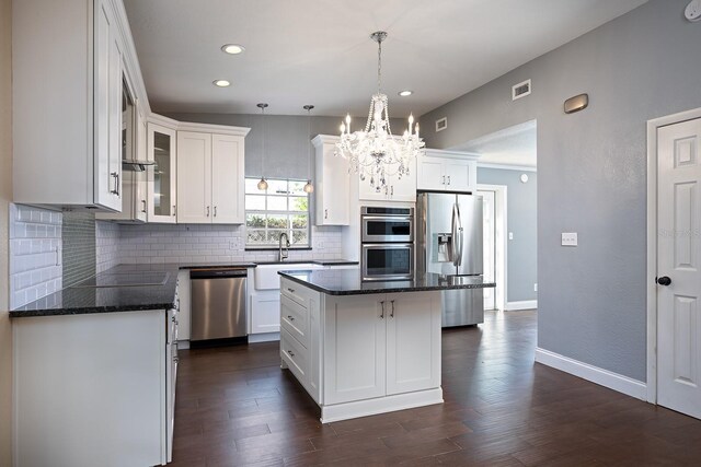 kitchen featuring stainless steel appliances, white cabinets, a center island, and dark hardwood / wood-style floors