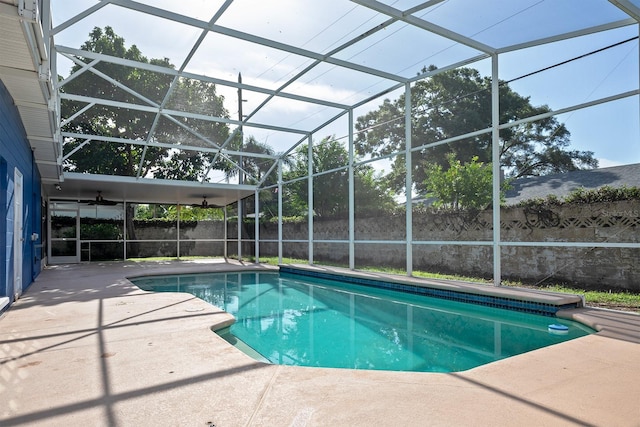 view of swimming pool featuring glass enclosure and a patio