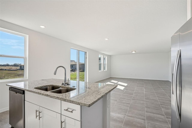 kitchen featuring a healthy amount of sunlight, appliances with stainless steel finishes, sink, and white cabinets