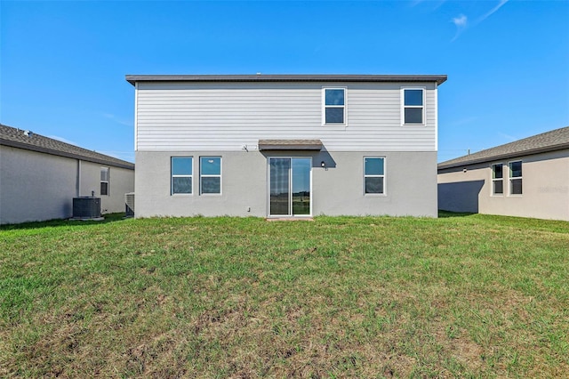 back of property featuring central AC unit and a lawn