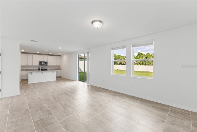 unfurnished living room featuring light tile patterned floors