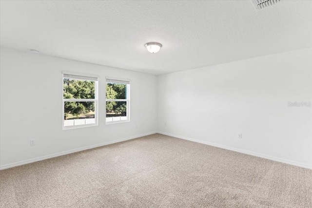 carpeted spare room featuring a textured ceiling