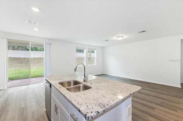 kitchen featuring an island with sink, sink, hardwood / wood-style flooring, and a healthy amount of sunlight