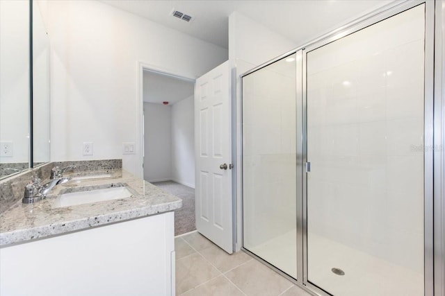 bathroom featuring tile patterned flooring, vanity, and a shower with shower door