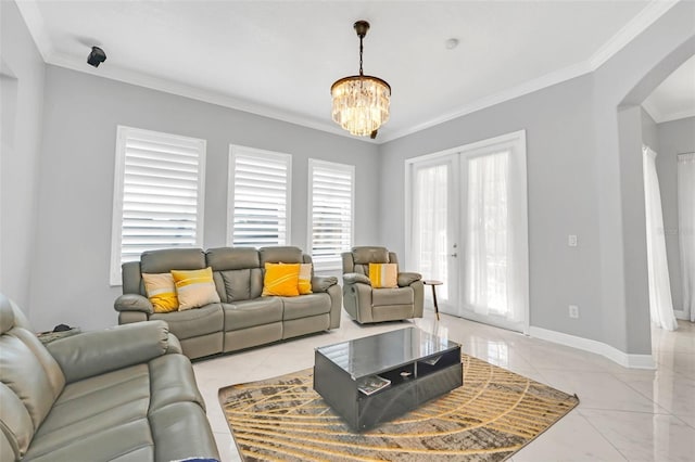 living room with ornamental molding, french doors, and a chandelier