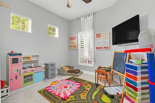 game room with ceiling fan, light tile patterned floors, and a healthy amount of sunlight