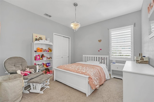 bedroom featuring light colored carpet and a chandelier