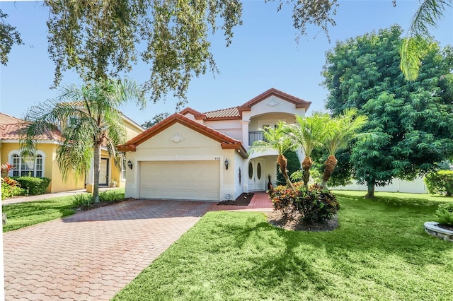 mediterranean / spanish home featuring a front lawn, a balcony, and a garage