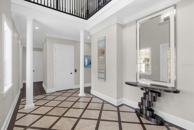 entryway featuring ornate columns, crown molding, and plenty of natural light