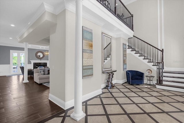 entrance foyer featuring ornamental molding, hardwood / wood-style flooring, and decorative columns