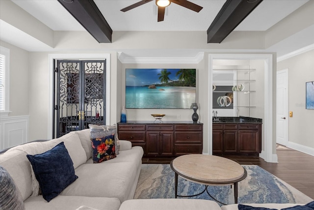 living room featuring ceiling fan, beamed ceiling, dark hardwood / wood-style floors, and sink