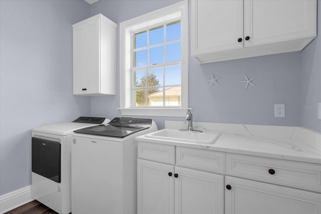 laundry room with dark hardwood / wood-style flooring, cabinets, sink, and washing machine and clothes dryer