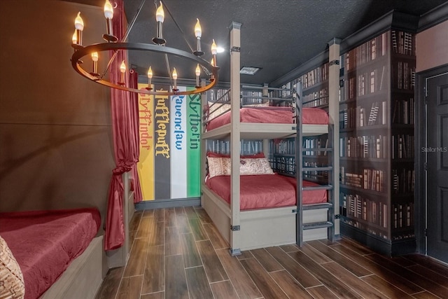 bedroom featuring a textured ceiling, hardwood / wood-style floors, and an inviting chandelier